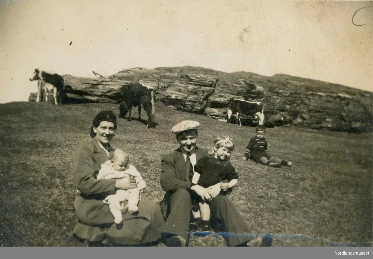 Dåpsdagen til Per Sverre Sommernes (f. 1940). Foreldrene Hjørdis Margrete og Sigurd Henry Pedersen Sommernes. På fanget til faren sitter Åse Anne. I bakgrunnen er en gutt og tre kyr.