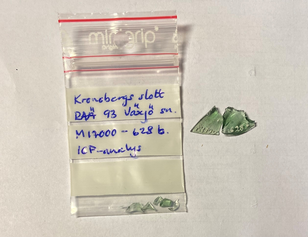 Fem fragment av en kupig bägare (vinglas) av ljusgrön glasmassa. En helt slät mynningsbit (a), tre bukbitar med små bucklor i relief, placerade i vertikala rader (b, c, d) samt en helt slät bukbit (e). M 17000-628 b valdes ut för ICP-analys i maj 2023.