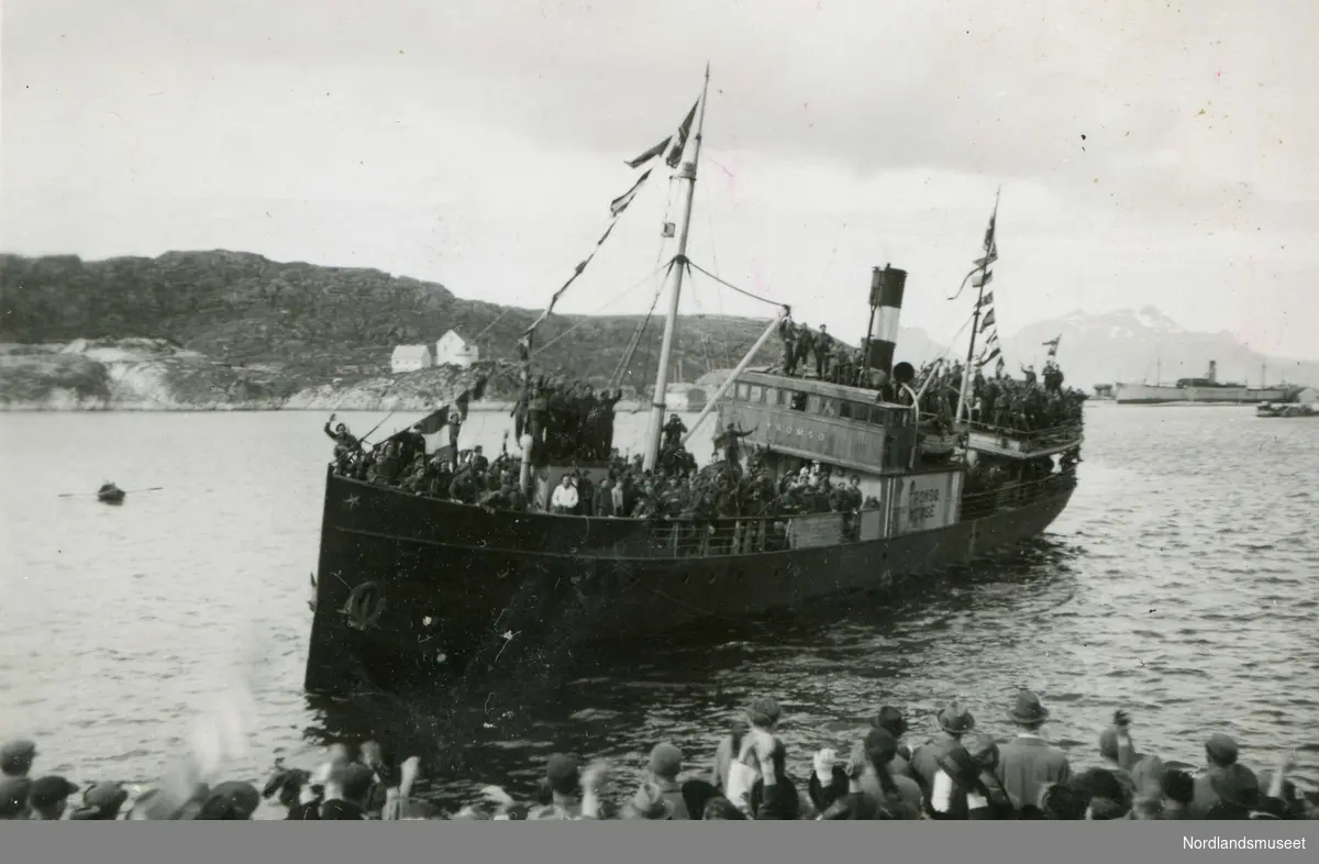 Dampskipet D/S Tromsø med soldater er iferd med å legge til kai. Mange mennesker på kaia for å ta imot dem. Antagelig etter frigjøringen i 1945.