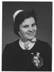 Bröstbild av Britt-Inger Johannesson, klädd i högtidsdräkt i samband med sjuksköterskeexamen vid Jönköpings läns landstings sjuksköterskeskola i december 1959.

Text på fotografiets baksida: 