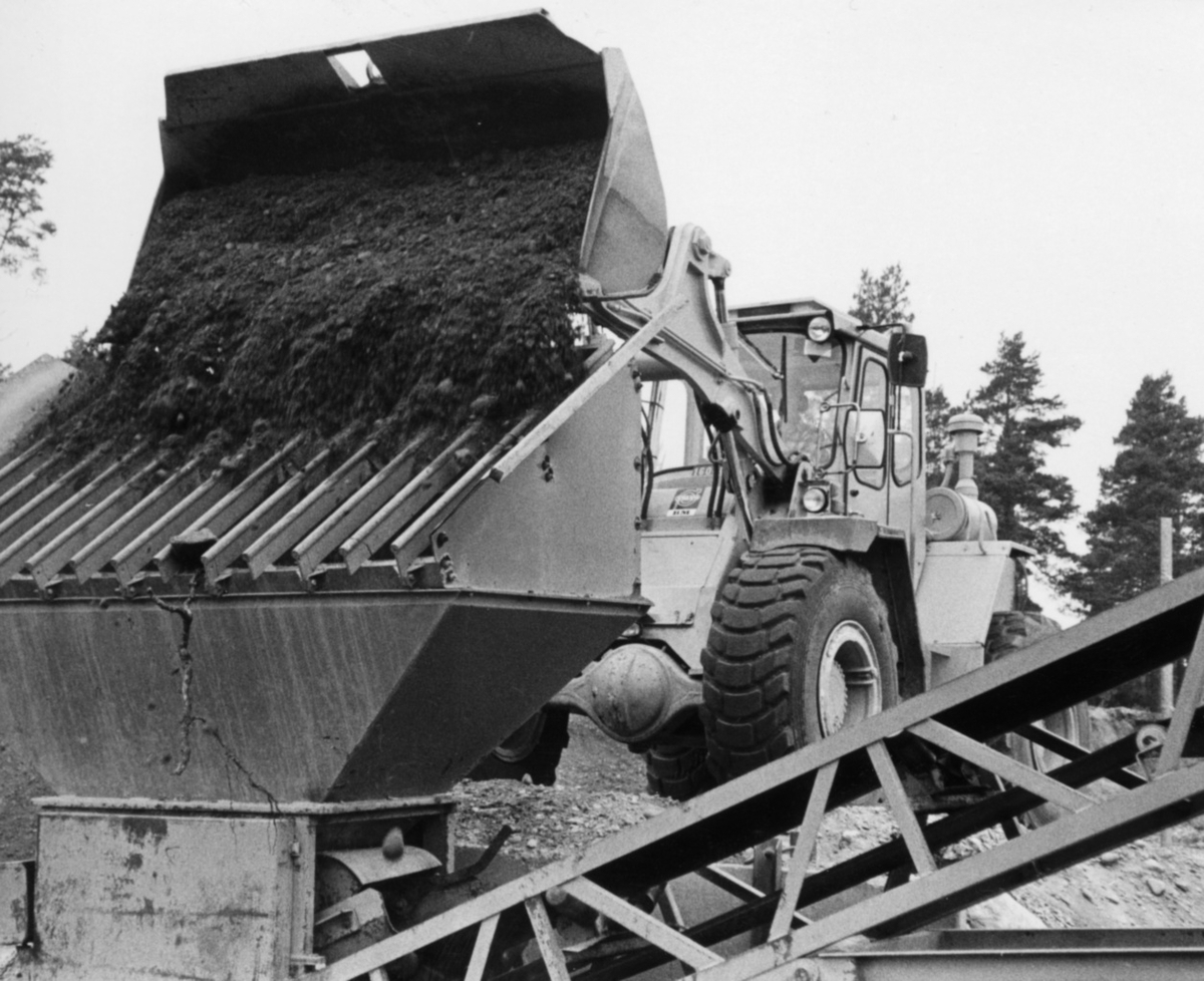 Nybyggnation av tre förråd 1986.

Några blandade bilder från de samtida byggprojekten i Utö läger; livsmedelsförrådet, kokhuset och Värnskolans förråd. 

Bild 1: Den blivande byggplatsen hitom reningsverket beskådas av projektledaren, kapten Staffan Löding vid Fortenheten på regementet.

Bild 2: Staffan Löding och arbetsledaren Kurt Madell ur hantverkargruppen vid Fortenheten.

Bild 3: Maskinföraren Tomas Larpe från Vägavdelningen vid Fortenheten kör lastmaskin och sköter stenkrossen.

Bild 4: Stenkrossen i full gång i grusgropen nära skjutbanan.

Bild 5: Tillverkning av fyllning. Tre skopor sten, en skopa grus och en halv skopa sand blandas.