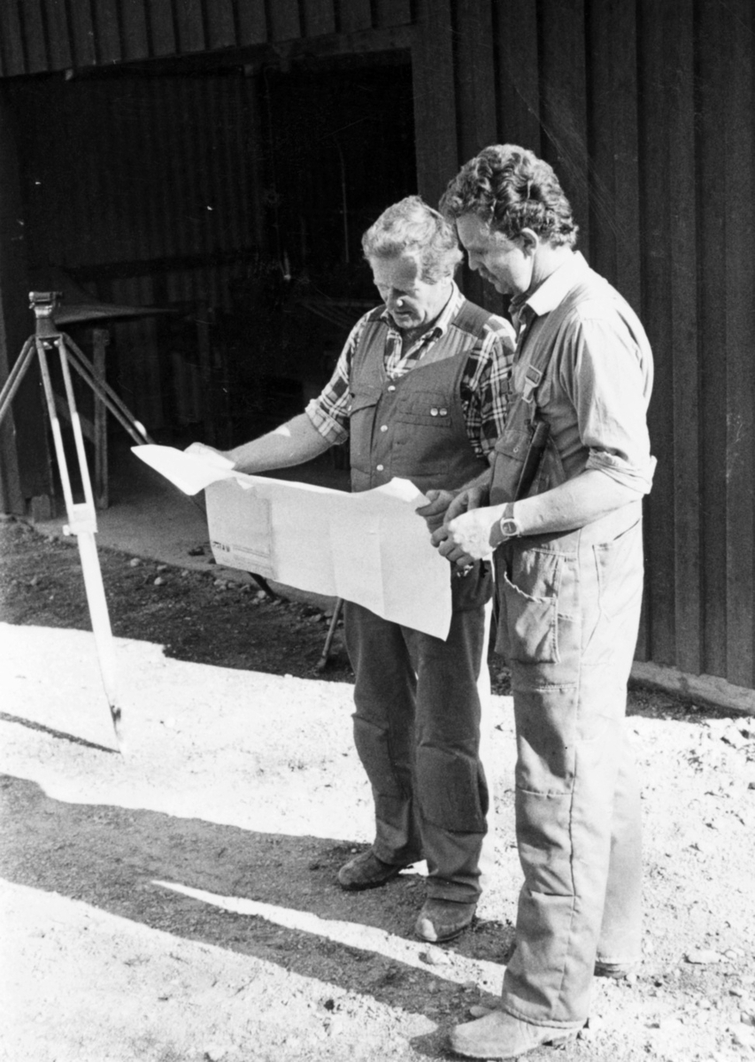 Nybyggnation av tre förråd 1986.

Några blandade bilder från de samtida byggprojekten i Utö läger; livsmedelsförrådet, kokhuset och Värnskolans förråd. 

Bild 1: Kurt Madell och Kjell Strömkvist studerar ritningen.

Bild 2: "Blommen" borrar och skjuter. Entreprenör som ofta togs in för sprängningsarbeten.

Bild 3: Kurt Madell på schaktbotten "Det ser riktigt bra ut!". Vägavdelningens D 7:a i bakgrunden.

Bild 4: Hämtning av grus vid Stora Stenstrand. Scania 111 från vägavdelningen, samt Volvo N88 och Volvo BM 846 som tillhörde skjutfältet.

Bild 5: Gruset lossas vid byggplatsen. Kjell Strömkvist och Sven Johansson utanför bilen.

Bild 6: Staffan Löding och maskinföraren Sven Johansson med sin Caterpillar D7.

Milregnr: 54815, 207794