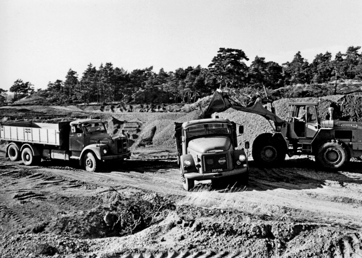 Nybyggnation av tre förråd 1986.

Några blandade bilder från de samtida byggprojekten i Utö läger; livsmedelsförrådet, kokhuset och Värnskolans förråd. 

Bild 1: Kurt Madell och Kjell Strömkvist studerar ritningen.

Bild 2: "Blommen" borrar och skjuter. Entreprenör som ofta togs in för sprängningsarbeten.

Bild 3: Kurt Madell på schaktbotten "Det ser riktigt bra ut!". Vägavdelningens D 7:a i bakgrunden.

Bild 4: Hämtning av grus vid Stora Stenstrand. Scania 111 från vägavdelningen, samt Volvo N88 och Volvo BM 846 som tillhörde skjutfältet.

Bild 5: Gruset lossas vid byggplatsen. Kjell Strömkvist och Sven Johansson utanför bilen.

Bild 6: Staffan Löding och maskinföraren Sven Johansson med sin Caterpillar D7.

Milregnr: 54815, 207794