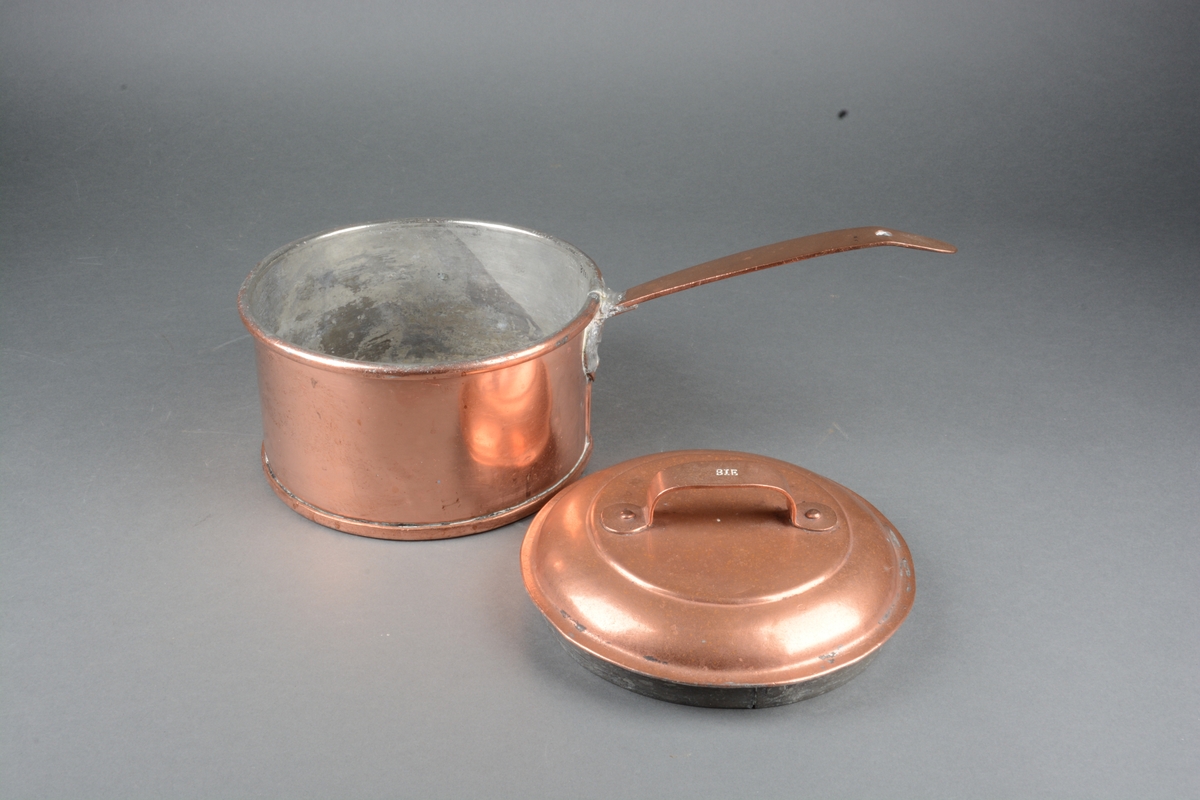 Kjele av kobber, med lokk og håndtak. Sinkbelegg inni.