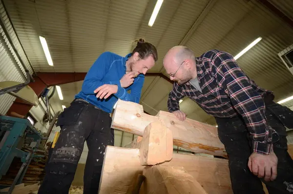 To håndverkere studerer laft