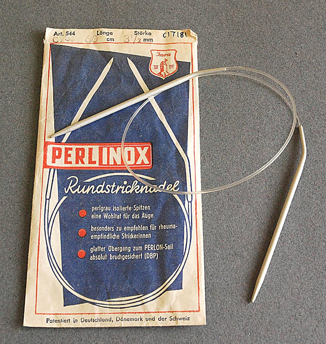 Rundsticka, två stickor med en plastlina emellan som mäter 60 cm med tjocklek 3½ mm som ligger i en liten pappersförpackning med ett tryck i vitt, rött , blått   pearlinox rundsticknadel
nyreg data feb 2003 lj