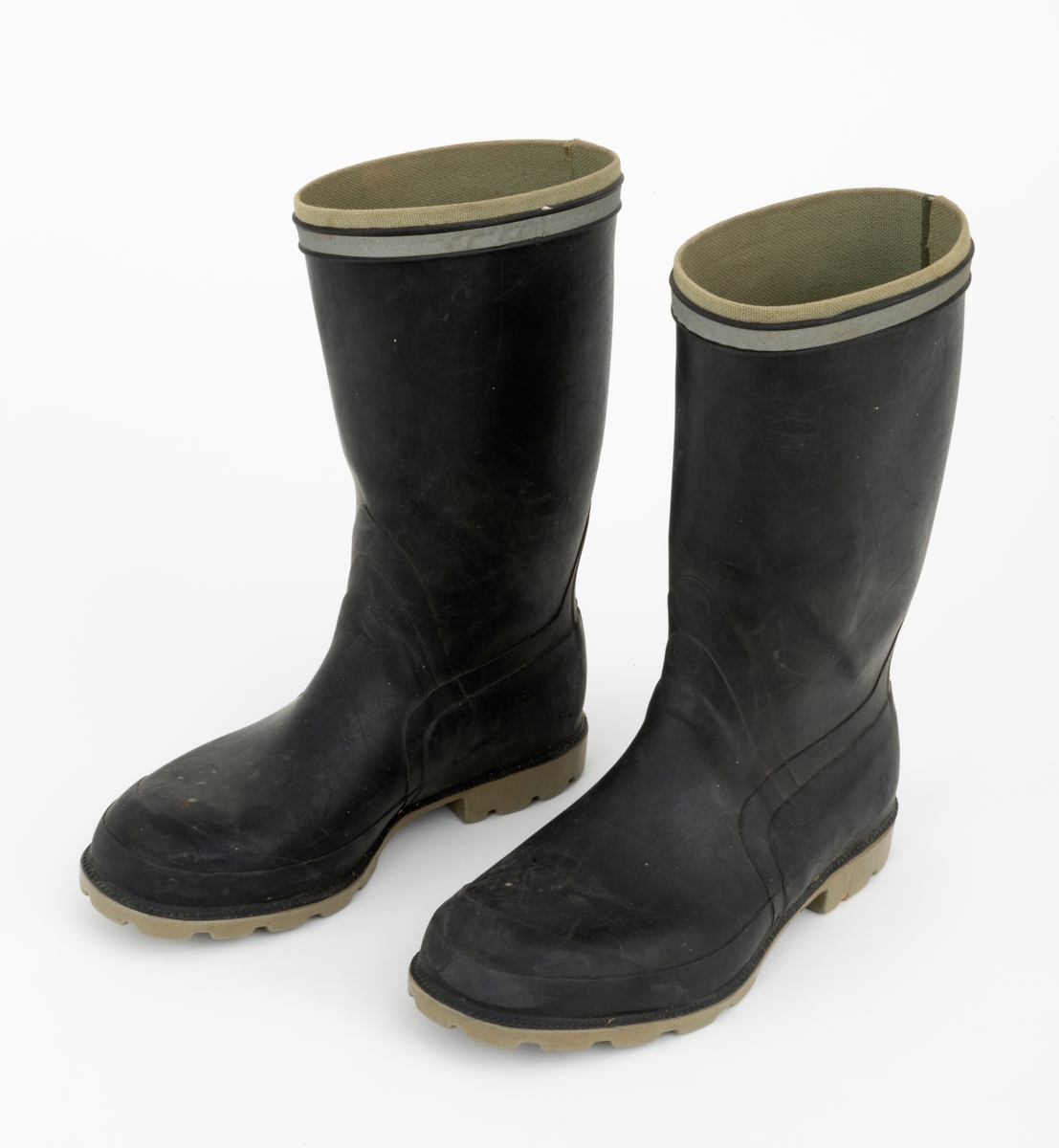 Gummistøvler eller langstøvler - vanntett fottøy med høye skaft - brukt under vandring på vått underlag utendør, sannsynligvis også i fjøs, der det var møkk på golvene. Dette støvleparet ble antakelig brukt av småbrukeren Iver Eide (1886-1976) fra Tolga på hans eldre dager. Støvlene har grålige såler med markerte hæler, og med 4,5 - 5,5 millimeter djupt riflemønster, som antakelig skulle forebygge at den som gikk med støvlene skled på glatt underlag. Ellers er støvlenes ytterflater lagd av mørkebrun, nesten svart gummi, som er noe tjukkere og mer solid langs sålene og mot hælene enn over vristpartiene og i skaftene. Rundt skaftenes overender er det pålimt cirka 1 centimeter brede refleksband. Innvendig er gummien trukket med et finmasket striestoff. Støvlene har innlagte såler av et tynt pappmateriale. Produsentens logo - en slags borg med tre tårn og firmnavnet «TRETORN», samt «MADE IN SWEDEN» og størrelsesbetegnelsen «40» - innstøpt på undersidene av sålene. Støvlebrukeren har tråkket en liten jernstrift inn i den høyre såla.