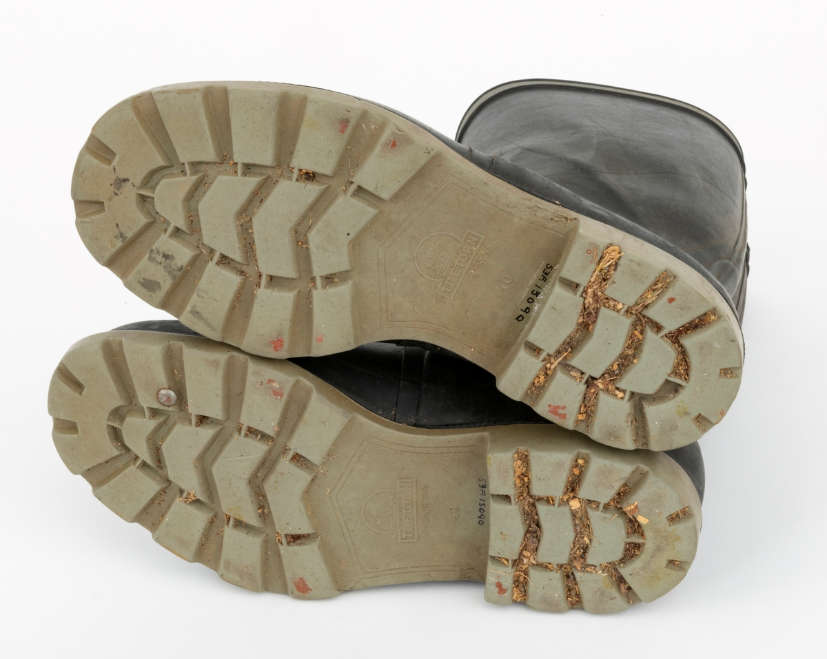 Gummistøvler eller langstøvler - vanntett fottøy med høye skaft - brukt under vandring på vått underlag utendør, sannsynligvis også i fjøs, der det var møkk på golvene. Dette støvleparet ble antakelig brukt av småbrukeren Iver Eide (1886-1976) fra Tolga på hans eldre dager. Støvlene har grålige såler med markerte hæler, og med 4,5 - 5,5 millimeter djupt riflemønster, som antakelig skulle forebygge at den som gikk med støvlene skled på glatt underlag. Ellers er støvlenes ytterflater lagd av mørkebrun, nesten svart gummi, som er noe tjukkere og mer solid langs sålene og mot hælene enn over vristpartiene og i skaftene. Rundt skaftenes overender er det pålimt cirka 1 centimeter brede refleksband. Innvendig er gummien trukket med et finmasket striestoff. Støvlene har innlagte såler av et tynt pappmateriale. Produsentens logo - en slags borg med tre tårn og firmnavnet «TRETORN», samt «MADE IN SWEDEN» og størrelsesbetegnelsen «40» - innstøpt på undersidene av sålene. Støvlebrukeren har tråkket en liten jernstrift inn i den høyre såla.