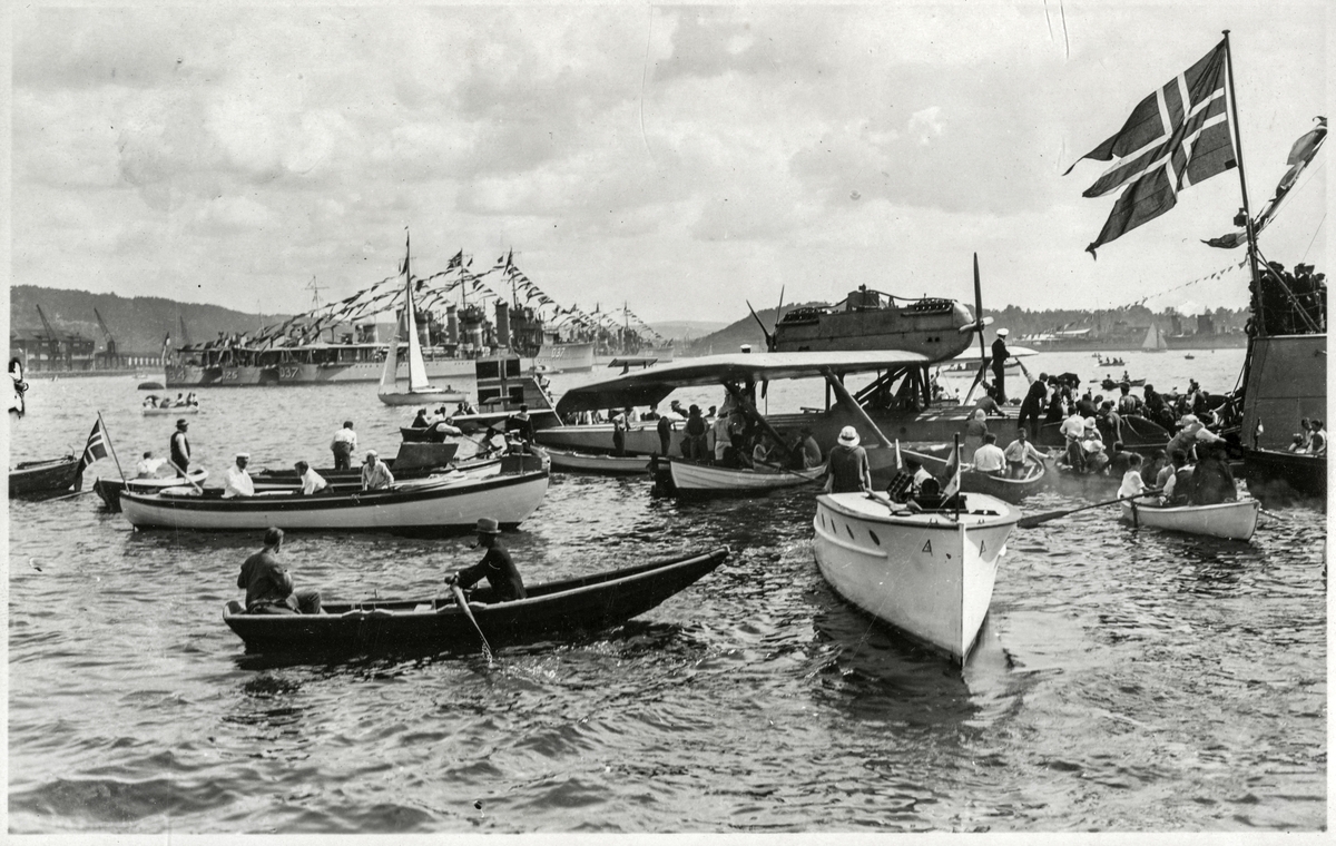 N25 (fly) med hvit lystbåt i forgrunnen og akterskip av et av Marinens panserskip - Roald Amundsens ankomst til Oslo med N25 - 4. juli 1925