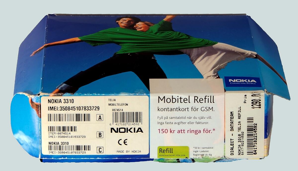 Nokia mobiltelefon modell 3310. Skal av mörkblått plast med silverfärgade knappar och rektangulär display. I originalkartong med laddare, billaddare, instruktionsbok och inköpskvitto.