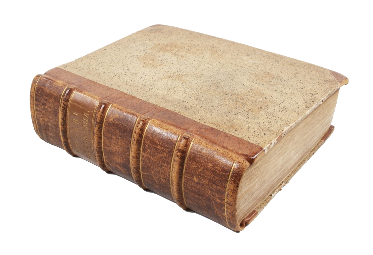 Trådbunden bok. Klädd med brunt skinn på rygg och hörn. Ryggen med präglad guldtext: "COLERI OECONOMIA" Fram och baksida i sandfärgad papp. Bladen ljusbruna och fläckiga med svart text. Första sidan med texten: "J. Coleri oeconomia, thet är, huushåldz underwijsning, förswänskat och i många rum utaf andra authoribus amplificerat och förbättrat af Isaco Erici, pastore Stenbyense......" Publicerad i "Stockholm. Tryckt uti Kongl. booktryckerijet, hos sal. Wankijfz änckia och med hennes egen bekostnad, åhr 1694".