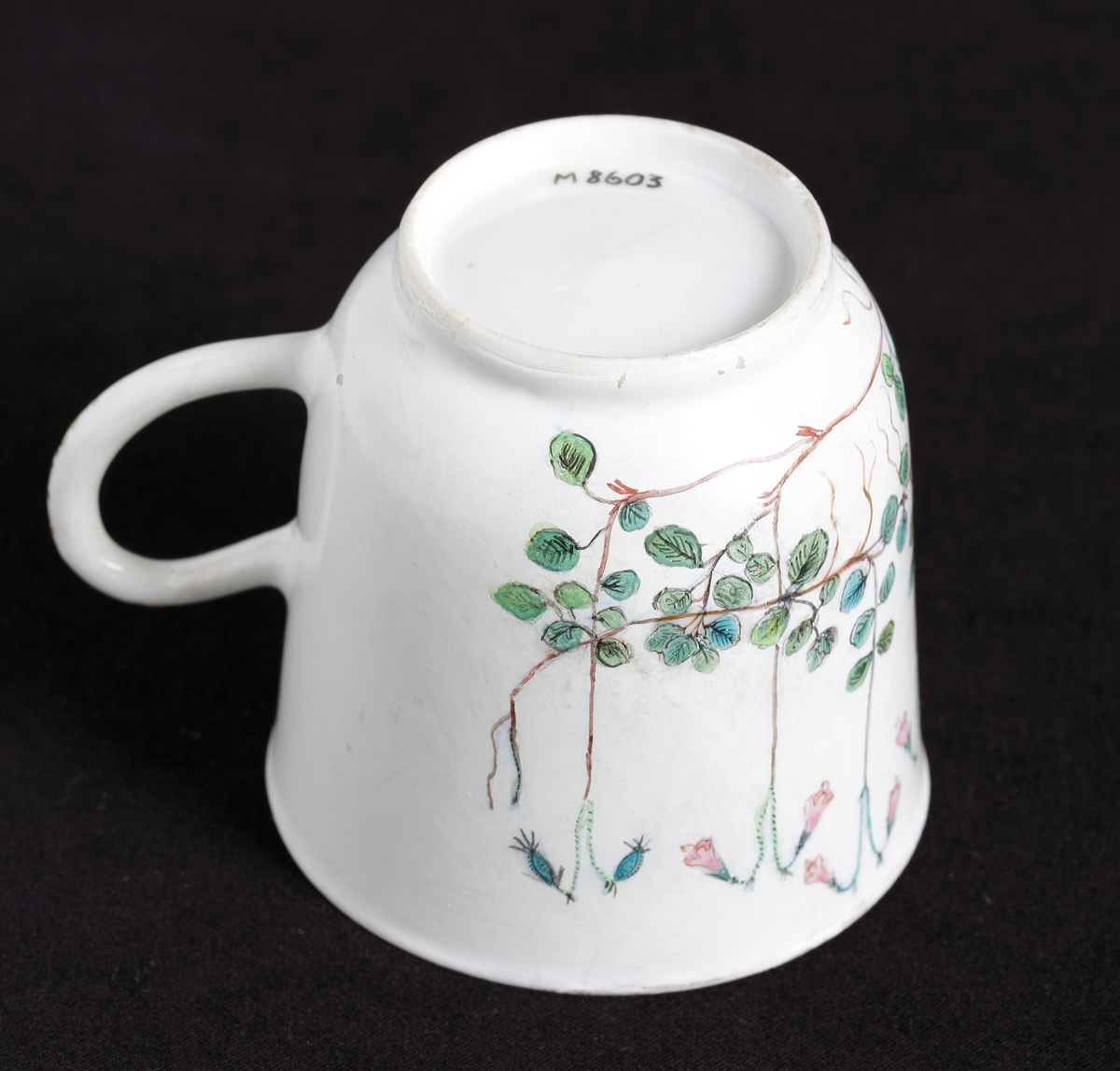 Kaffekopp med dekor av blommande linnéor i rosa och gröna nyanser runt om. 
Tillhörande tefat finns.

Inskrivet i huvudkatalog 1935.