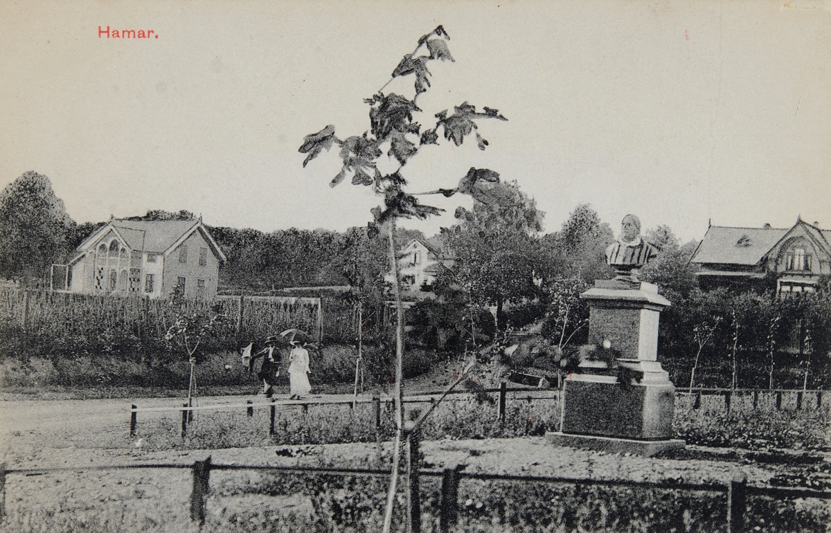 Postkort, Hamar, Sagatun, byste av biskop Halvor Olsen Folkestad utenfor Hamar domkirke, bysten ble reist ved Hamar bys 50 årsjubileum 21. mars i 1899, Folkestad var biskop i Hamar fra 1864 til 1887,