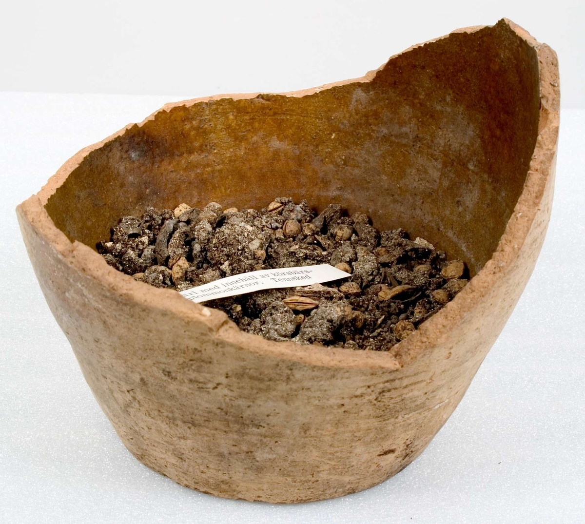 Kärl, delar av kärl. Keramik, lergods.
1) Fat med vitlerdekor. Målat årtal ...34.
2) En kruka med kärnor från körsbär och plommon.
3) Två fat.