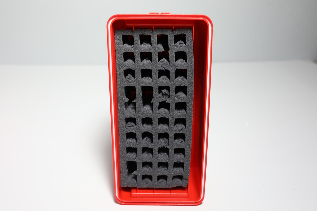 Bag med rom til tre bokser "Vacuette Transport Box" som det ble fraktet Covid-tester i. Glidlås rundt toppen av bagen. Den har håntak i midten av toppen, og på kortside er det feste for strop som man kan bære bagen med. På baksiden er det plastlomme med informasjon. Boksene har gjennomsiktige lokk, og har skumformer i til å plassere opp til 40 testrør i.