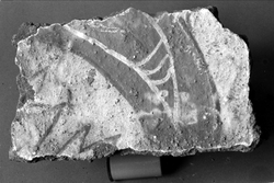 Tegelfragment med kalkmålning. Målad yta 20 x 12 cm. Brunrött svängt, avsmalnande band med vit dekor på ljusgrå botten. I ena hörnet fyra ljusgröna spetsar.