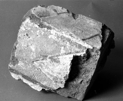 Tegelfragment med kalkmålning. Målad puts på tre ytor. Sidor 16 x 15 cm, gult med grå spets. Brunröd linje i ena kanten, svart i den andra. Underdel, 18 x 7 cm, gul-röd-brunt fält omgivet av ljusgrå f...