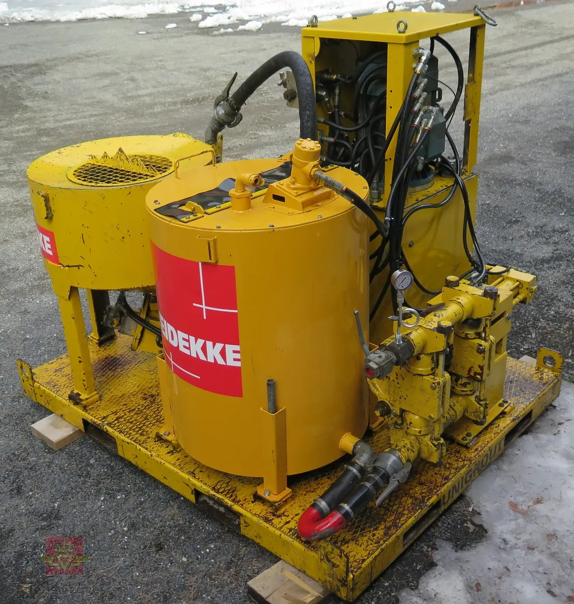 UNIGROUT injeksjonsflak. Elektrisk/hydraulisk drevet. Pumper, tanker og slanger bygd på ei plate. Hovedfragen er gul. Flaket har merking fra flere firmaer.