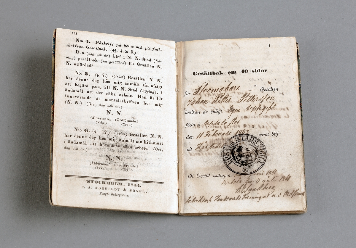 Gesällbok utfärdad 1861. Stämplad med Uppsala stads sigill, krönt lejon. pappärm, spräcklig i grönt, rött och blått. På framsidan försedd med etikett med bläckinskrift; J. P, Pettersson.