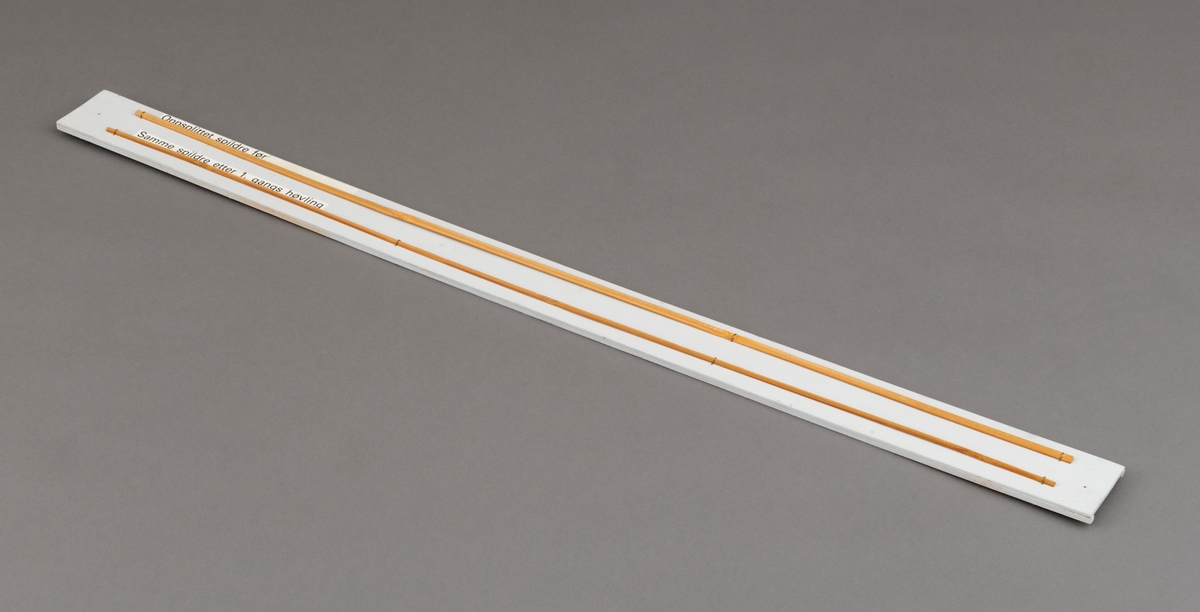 To splitcaneribber, spildrer av bambus (tonkinbambus), montert på en hvitmalt treplate. Spildrene har sitt utgansgpunkt i et bambusråemne (tonkinbambus) som er splittet opp og industrielt behandlet i firmaet Asbjørn Hørgårds maskiner, for deretter å bli limt sammen til fiskestenger.  Montasjen med de to spildrene har vært utstilt i museets basisutstilling om ferskvannsfiske fram til cirka 2013.

På den hvite treplata ses øverst en oppslittet spildre før høvling og nederst en spildre (ribbe) etter først gangs høvling. En stangdel i den ferdige fiskestanga, splitcanestanga, bestod av 6 ribber (spildrer). 

[Se referanser og referanser til filer for mer informasjon om hvordan framstillingen av splitkeinstenger foregikk. Se fanen "Opplysninger" for informasjon om Asbjørn Hørgård og hans firma. ]