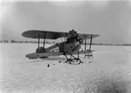 Flygplan Phönixjagaren, J 1 med skidor står på flygfältet på Malmen, vintertid omkring 1921-1924.