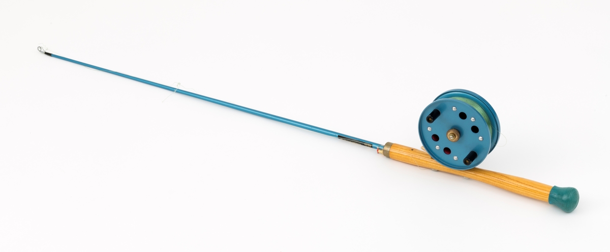 Fiskestang, havfiskestang, pilestang for sjøfiske fra båt produsert av firmaet Asbjørn Hørgård A/S med modellbetegnelsen "Napptun Pilkesett". Det er påmontert pilke- og dorgesnelle på stanga.  Stanga er produsert i massiv glassfiber, håndtak i tre med gummiknott i enden. Snella er skruddd fast til håndtaket med gjennomgående skruer. Snellefoten, antatt av messing, er naglet fast til snella.   
I salgskatalogen"Råd og redskap fra Hørgård" i 1975 er  "Napptun Pilkesett" beskrevet slik: "Asbjørn Hørgård har med sin kveite på 58 kg bevist at man kan ta storfisk med Napptun. Solid 4 1/2' pilkestang, en 5 1/2'' pilke- og dorgesnelle med 100 m 0.70 Triple Fish snøre, 1 Stingsild og 1 May Fly opphenger. Leveres ferdig montert. Pris: kr. 220,-" [Stingsild og May Fly opphenger er ikke montert på stang SJF.15050.]

I salgskatalogen "Råd og redskap fra Hørgård" i 1984 er Snella beskrevet slik: "Napptun snelle 5 1/2' * K(EK) Enklere kan en snelle knapt bli. Du kan enten bruke den som pilkesnelle eller du kan dorge med den på sjøen eller etter større innlandsfisk. Snelle har klikk som gir deg et signal når fisken går på. Klikken slår du på ved å skyve på knotten bak. Den store trommelen gjør at det er lett å ta inn fisk. På kanten av spolen har du en bremseflate, som du legger håndflaten på når fiske renner ut. Kan anbefales sammen Frøya. Pris: Napptun m/klikk kr. 205. 


[Se fanen Opplysninger for informasjon om Asbjørn Hørgård og hans firma.]