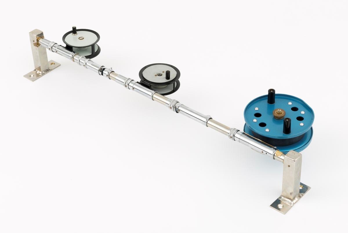 Tre fiskesneller, to fluesneller og en dorge- pilkesnelle, montert på et rør (en stang) med fem snellfester. I og med at det er fem snellefester kan det tyde på at det en gang har vært montert fem sneller på stanga. Snellene er produsert av firmaet Asbjørn Hørgård A/S i Trondheim. I hver ende av røret er det montert fester som gjør det mulig å montere stanga med fiskesneller til vegg. Snellene sitter festet på undersiden av stanga når de brukes, altså med snellefoten opp. 

I salgskatalogen "Råd og redskap fra Hørgård" i 1984 er den blå dorge- pilksnella  beskrevet slik: "Napptun snelle 51/2' * K(EK) Enklere kan en snelle knapt bli. Du kan enten bruke den som pilkesnelle eller du kan dorge med den på sjøen eller etter større innlandsfisk. Snelle har klikk som gir deg et signal når fisken går på. Klikken slår du på ved å skyve på knotten bak. Den store trommelen gjør at det er lett å ta inn fisk. På kanten av spolen har du en bremseflate, som du legger håndflaten på når fiske renner ut. Kan anbefales sammen Frøya. Pris: Napptun m/klikk kr. 205."
Diameter sidedeksel: 14 cm. Bredde målt frfa ytterside av sveivknapper til ytterside av sidedeksel: 8, 2 cm. 

Fluesnellene: Snellene består av spole (trommel), sidedeksler, ramme, sveiv og snellefot. Sveiva er montert direkte på spolen. 
På svart og hvit fluesnelle som er merket Trout Fly sitter sveivknappen løst. Snella merket Trout Fly har disse målene: 
Bredde målt fra ytterside av sveivknapp til ytterside av sidedeksel: 5,6 cm. Bredde spole, innvendig målt: 2,4 cm Diameter sidededeksel: 9,1 cm.
I Hørgård-firmaets bok "Norwegian made fishing tackle" fra 1964 er denne snelletypen beskrevet slik: "Trout Fly 3 1/2" Guttsnelle, passende for flue-, mark- og dorgefiske."

På svart og hvit fluesenlle som er merket Å H Hørgård er disse målene tatt: 
Bredde målt fra ytterside av sveivknapp til ytterside av sidedeksel: 6,4 cm. Bredde spole, innvendig målt: 2,2 cm Diameter sidededeksel: 8,9 cm.
I Hørgård-firmaets bok "Norwegian made fishing tackle" fra 1964 er denne snelletypen beskrevet slik: "Ørret fluesnelle 3 1/2'' ca. 170 gr. Presjonsarbeid med utsøkt materiale. Helstøpt lettmetall. Brennlakkert. Kapasitet: 30 yds. tapered fluesnøre og ca. 50 yds. bakline."



[Se fanen Opplysninger for informasjon om Asbjørn Hørgård og hans firma.]