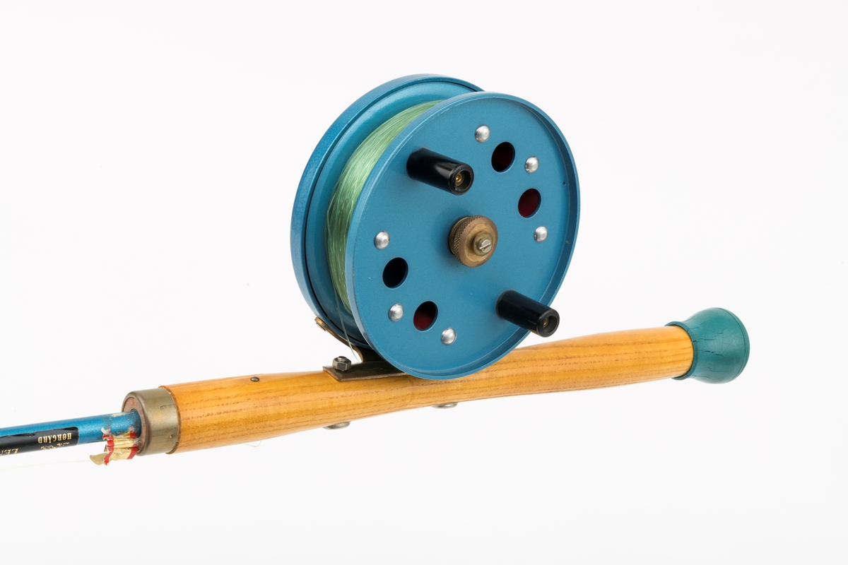 Fiskestang, havfiskestang, pilestang for sjøfiske fra båt produsert av firmaet Asbjørn Hørgård A/S med modellbetegnelsen "Napptun Pilkesett". Det er påmontert pilke- og dorgesnelle på stanga.  Stanga er produsert i massiv glassfiber, håndtak i tre med gummiknott i enden. Snella er skruddd fast til håndtaket med gjennomgående skruer. Snellefoten, antatt av messing, er naglet fast til snella.   
I salgskatalogen"Råd og redskap fra Hørgård" i 1975 er  "Napptun Pilkesett" beskrevet slik: "Asbjørn Hørgård har med sin kveite på 58 kg bevist at man kan ta storfisk med Napptun. Solid 4 1/2' pilkestang, en 5 1/2'' pilke- og dorgesnelle med 100 m 0.70 Triple Fish snøre, 1 Stingsild og 1 May Fly opphenger. Leveres ferdig montert. Pris: kr. 220,-" [Stingsild og May Fly opphenger er ikke montert på stang SJF.15050.]

I salgskatalogen "Råd og redskap fra Hørgård" i 1984 er Snella beskrevet slik: "Napptun snelle 5 1/2' * K(EK) Enklere kan en snelle knapt bli. Du kan enten bruke den som pilkesnelle eller du kan dorge med den på sjøen eller etter større innlandsfisk. Snelle har klikk som gir deg et signal når fisken går på. Klikken slår du på ved å skyve på knotten bak. Den store trommelen gjør at det er lett å ta inn fisk. På kanten av spolen har du en bremseflate, som du legger håndflaten på når fiske renner ut. Kan anbefales sammen Frøya. Pris: Napptun m/klikk kr. 205. 


[Se fanen Opplysninger for informasjon om Asbjørn Hørgård og hans firma.]