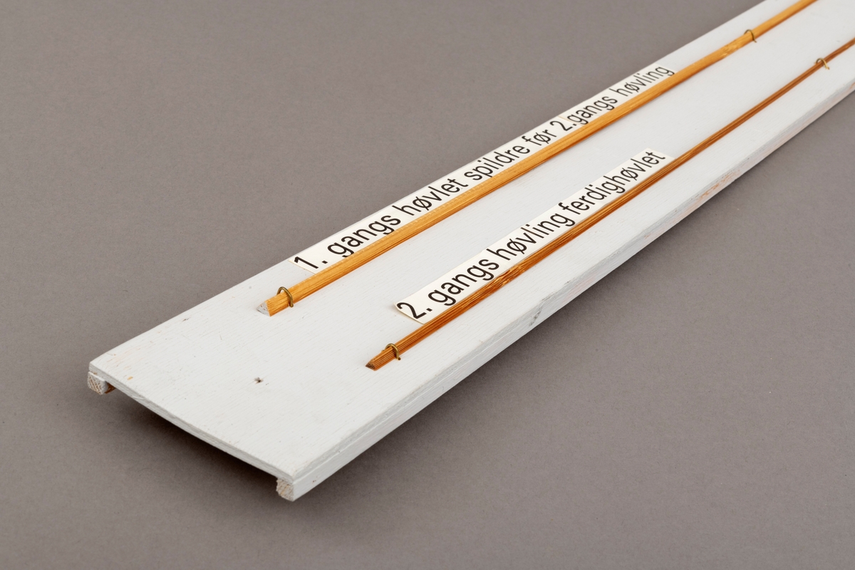 To splitcaneribber, spildrer av bambus (tonkinbambus), montert på en hvitmalt treplate. Spildrene har sitt utgansgpunkt i et bambusråemne (tonkinbambus) som er splittet opp og industrielt behandlet i firmaet Asbjørn Hørgårds maskiner, for deretter å bli limt sammen til fiskestenger.  Montasjen med de to spildrene har vært utstilt i museets basisutstilling om ferskvannsfiske fram til cirka 2013.

På den hvite treplata ses øverst en 1. gangs høvlet spildre før 2. gangs høvling og nederst en spildre (ribbe) etter 2. gangs høvling og som regnes som ferdig høvlet. En stangdel i ferdige fiskestanga, splitcanestanga, bestod av 6 ribber (spildrer). 

[Se referanser og referanser til filer for mer informasjon om hvordan framstillingen av splitkeinstenger foregikk. Se fanen "Opplysninger" for informasjon om Asbjørn Hørgård og hans firma. ]