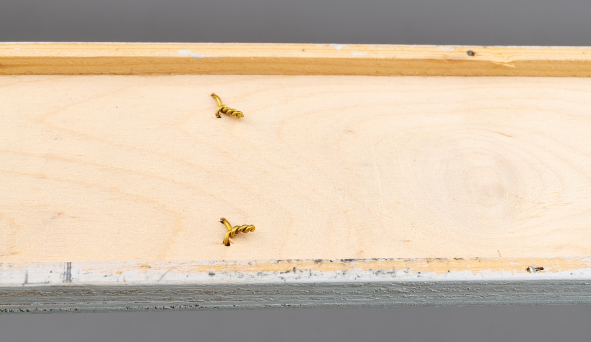 To splitcaneribber, spildrer av bambus (tonkinbambus), montert på en hvitmalt treplate. Spildrene har sitt utgansgpunkt i et bambusråemne (tonkinbambus) som er splittet opp og industrielt behandlet i firmaet Asbjørn Hørgårds maskiner, for deretter å bli limt sammen til fiskestenger.  Montasjen med de to spildrene har vært utstilt i museets basisutstilling om ferskvannsfiske fram til cirka 2013.

På den hvite treplata ses øverst en 1. gangs høvlet spildre før 2. gangs høvling og nederst en spildre (ribbe) etter 2. gangs høvling og som regnes som ferdig høvlet. En stangdel i ferdige fiskestanga, splitcanestanga, bestod av 6 ribber (spildrer). 

[Se referanser og referanser til filer for mer informasjon om hvordan framstillingen av splitkeinstenger foregikk. Se fanen "Opplysninger" for informasjon om Asbjørn Hørgård og hans firma. ]