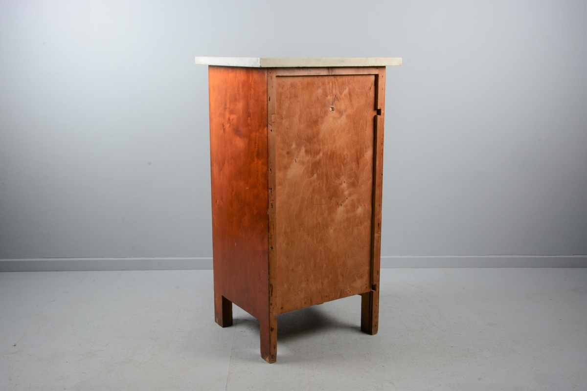 Nattbord med skuff, skap og marmorplate på toppen (plata er laus). Skuffen og skapet har messingknotter. Skapet har fyllingsdør som har opning mot venstre og skal dermed stå på venstre side av senga.