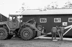 Nybyggnation av tre förråd 1986.

Några blandade bilder från de samtida byggprojekten i Utö läger; livsmedelsförrådet, kokhuset och Värnskolans förråd. 

Bild 1: En av de platsbyggda takstolarna förbereds för montering.

Bild 2: Kök och förråd till Värnskolan (efter att Värnskolan lagts ned används byggnaden som dykmaterielförråd).

Bild 3: Kurt Madell i spikartagen!

Bild 4: Kurt kollar att taktolen är i lod.

Bild 5: Alla takstolar på plats.

Bild 6: Detaljbild över takstol. Lägg märke till att spikplattor i trä används, spikplåtar var nog lite för modernt för konstruktören vid Milostabens Byggnadskontor.