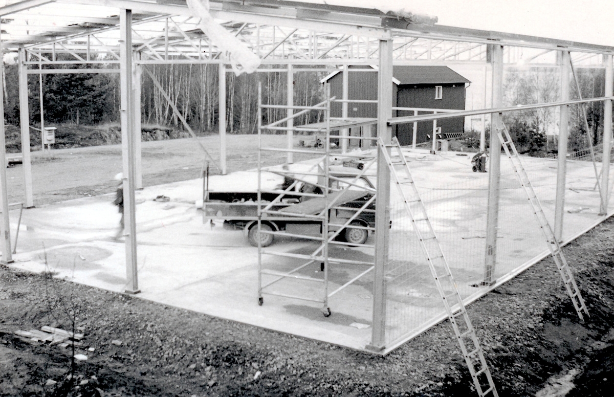 Nybyggnation av tre förråd 1986.

Några blandade bilder från de samtida byggprojekten i Utö läger; livsmedelsförrådet, kokhuset och Värnskolans förråd. 

Bild 1: Staffan Löding och Kurt Madell diagonalmäter plattan så att stomresningen kan få starta.

Bild 2: Stålstommen till plåtförrådet rest.

Bild 3: Profiler till en av de andra byggnaderna monteras.

Bild 4: Kurt Madell och Kjell Strömkvist studerar ritningar.

Bild 5: Sulan till livsmedelsförrådet rak och fin!