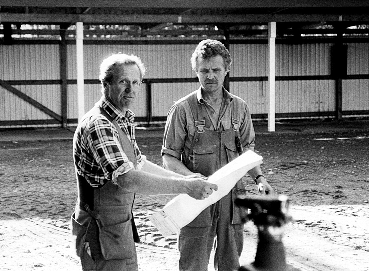 Nybyggnation av tre förråd 1986.

Några blandade bilder från de samtida byggprojekten i Utö läger; livsmedelsförrådet, kokhuset och Värnskolans förråd. 

Bild 1: Staffan Löding och Kurt Madell diagonalmäter plattan så att stomresningen kan få starta.

Bild 2: Stålstommen till plåtförrådet rest.

Bild 3: Profiler till en av de andra byggnaderna monteras.

Bild 4: Kurt Madell och Kjell Strömkvist studerar ritningar.

Bild 5: Sulan till livsmedelsförrådet rak och fin!
