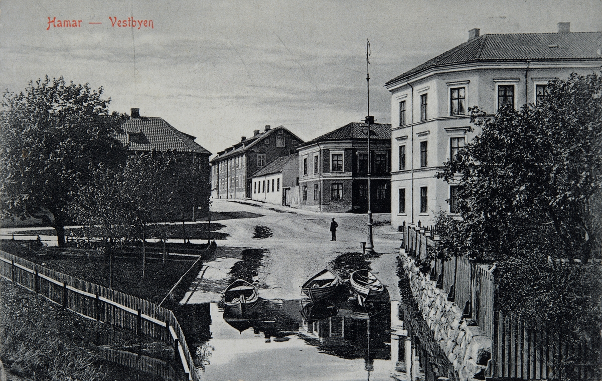 Postkort, Hamar, Lille Strandgate 3 - Skappels gate 3, Morteruds gate, Mjøsflommen i juni 1910, robåter trekt opp i gata, ser taket til Skappels gate 2 til venstre,