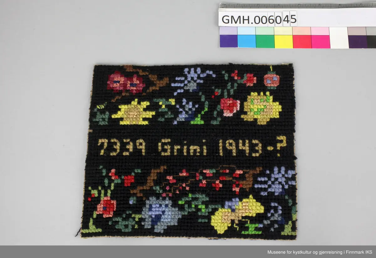 Korsstingbroderiet er utført med bomullsgarn i ulike farger på et  vevd grunnstoff som sannsynlig er av papirmateriale. Motivet viser blåe, gule og røde blomster på svart grunn. I midten ble det brodert inn fangenumre som Agathe Elfrida Hansen fikk tildelt i Grini fangeleir.