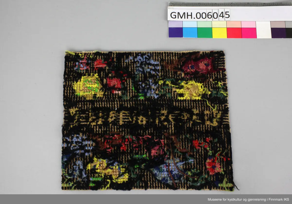 Korsstingbroderiet er utført med bomullsgarn i ulike farger på et  vevd grunnstoff som sannsynlig er av papirmateriale. Motivet viser blåe, gule og røde blomster på svart grunn. I midten ble det brodert inn fangenumre som Agathe Elfrida Hansen fikk tildelt i Grini fangeleir.