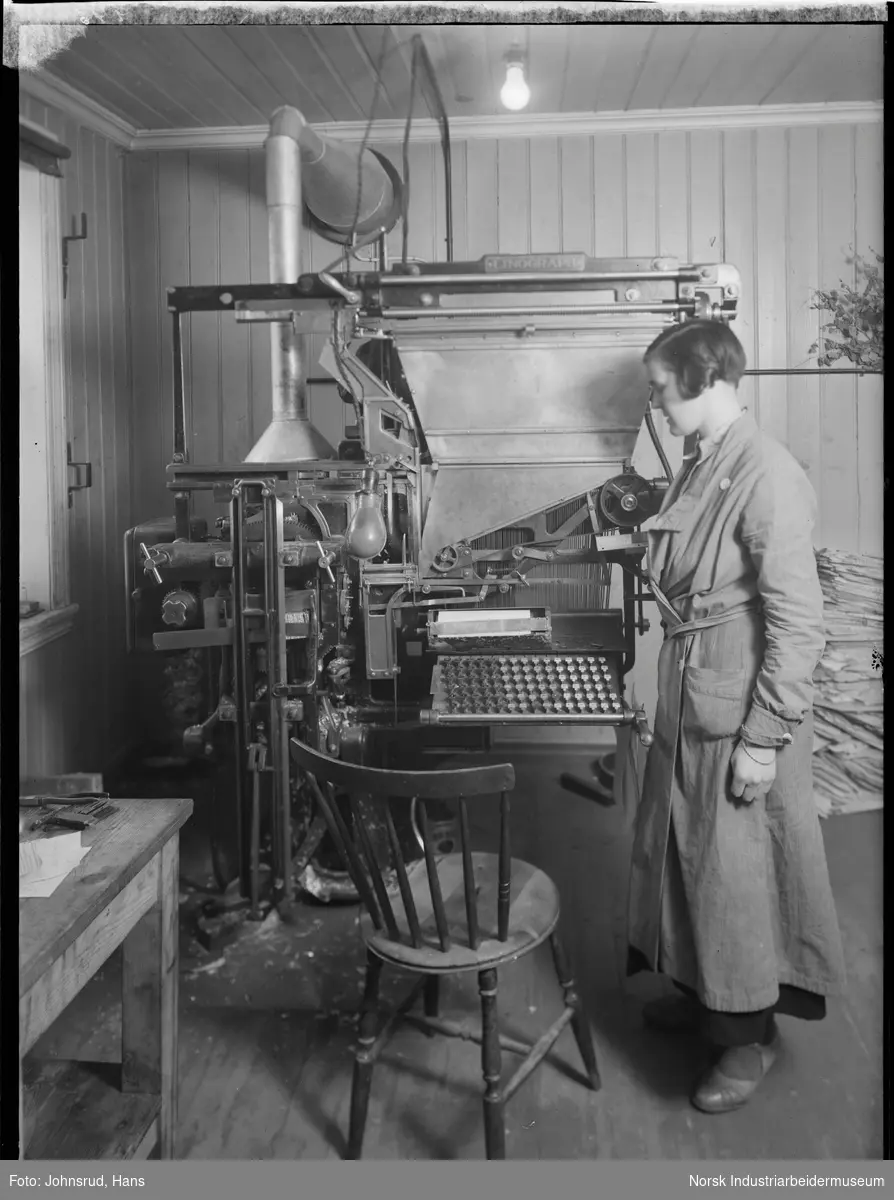 Kvinne stående ved settemaskin av merket Linograph på Telen.