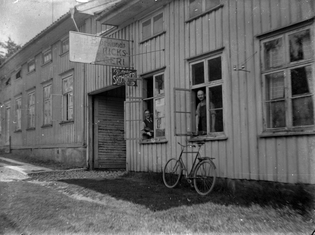 Två män tittar ut genom fönstret från Carl Björklunds bryggeri på Nygatan.