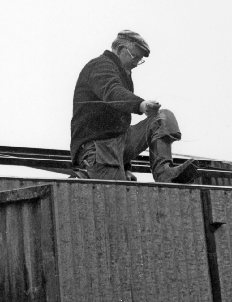 Nybyggnation av tre förråd 1986.

Utöver det tre förråden vid lägret monterades också ett enkelt emballageförråd vid ammunitionsförrådet på ön. Plåtskjulet hade tidigare stått vid Miloverkstaden i Strängnäs.

Denna typ av skjul byggdes också i vallbydalgången på Härads skjutfält och vid ammunitionsförrådet på N fältet i Strängnäs (typ E VI u).

Bild 1: Kurt Madell på taket och Kjell Strömkvist i dörröppningen.

Bild 2: Kurt på taket och hantverkaren Einar Lantz.

Bild 3: Einar ser ut att hålla på med någon metalltråd.

Bild 4: Hantverkaren Lars-Olov Sellberg mäter upp takplåt.

Bild 5: Kjell Strömkvist skruvar ihop väggsektioner.