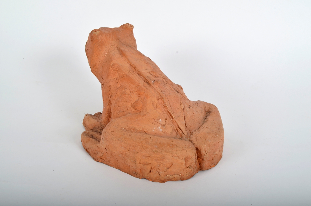 Froskefigur i rød terracotta.