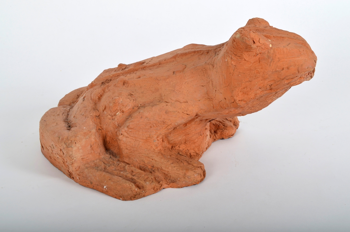 Froskefigur i rød terracotta.
