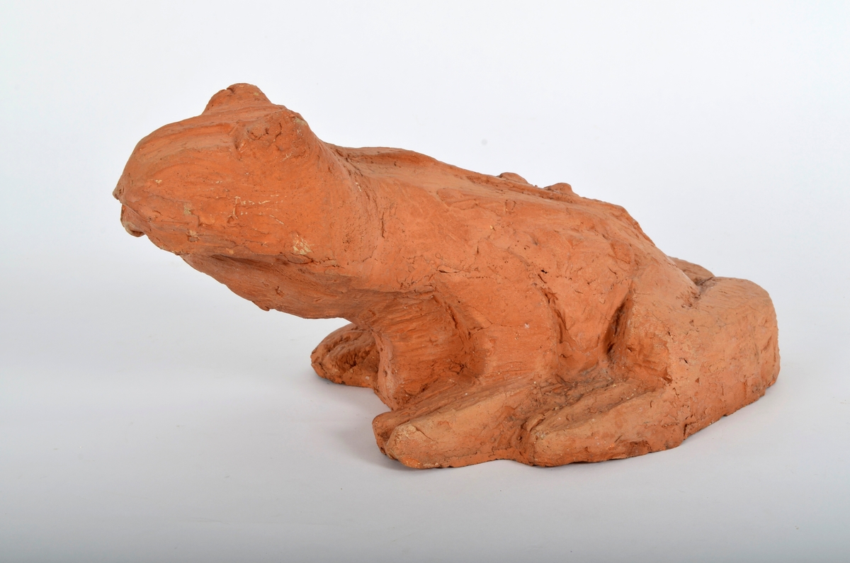Froskefigur i rød terracotta.