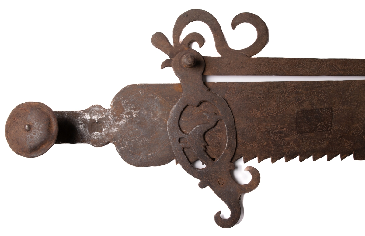 Järnföremål, okänd användning. Möjligen slangringsregel till stor ugn. Märkt 1799.
Avlångt med brutna ornament vid ändanrna liknande krona och fågelfigur.
Till vänster ett kraftigt knoppformigt handtag. Framsidan täckt av ristade ornament: slingor med glesa tvärstreck, blommor, m.m.
Otydligt smedsmärke, se skiss.