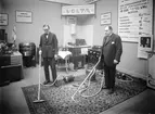 Nya Elektriska AB demonstrerar förträffligheten med dammsugaren Volta. Från utställning omkring 1930, sannolikt i Linköping.