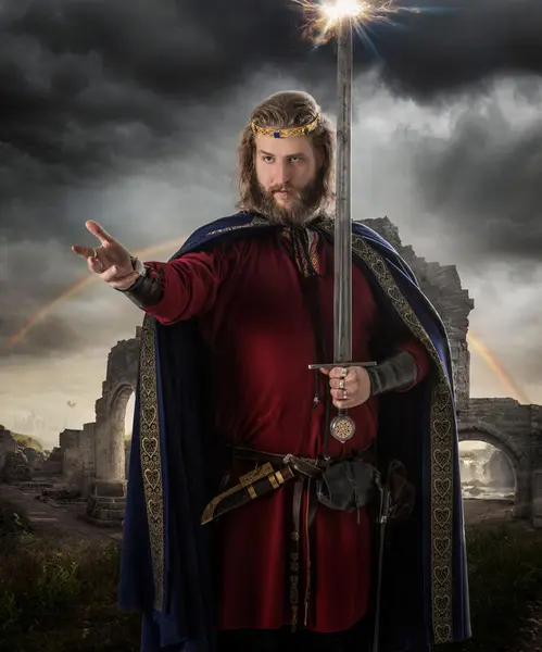 Fantasyprins med sverd i rød kjortel, blå kappe og krone