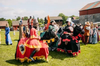 Små lekehester med mennesker inni. En svart med rødt dekken. Ridderen er også kledd i rødt. En grå med grønt dekken. Ridderen kledd i grønt. En brun med blått dekken og ridder kledd i blått