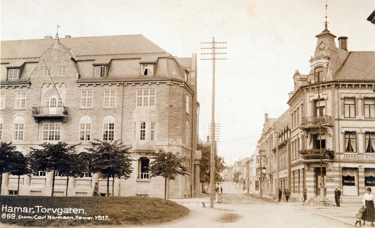 Postkort, Hamar, Jernbaneplassen, Torggata 12 Vangs sparebank, i Parkgata 12 Norsenggården med Jernbanehotellet og Park Cafe, lysstolper,