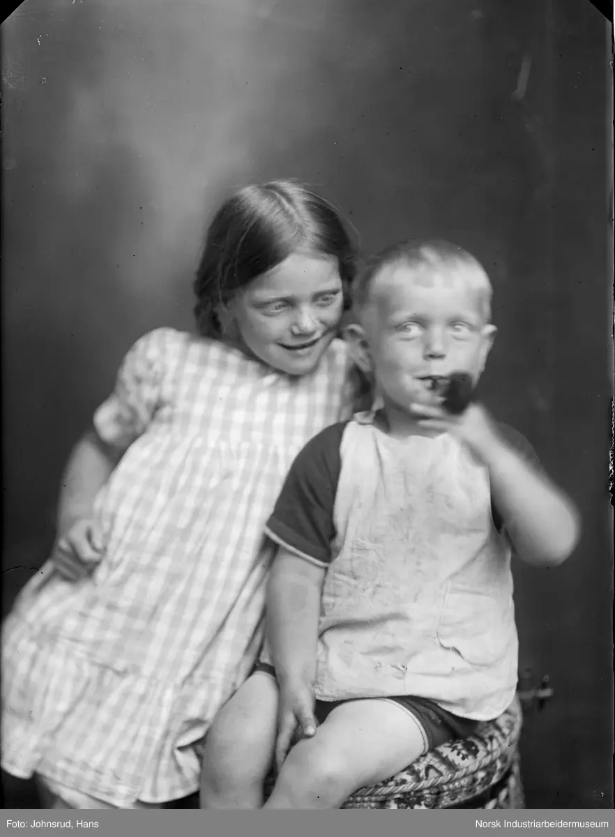 Portrett. To barn i studio, en med pipe i munnen.