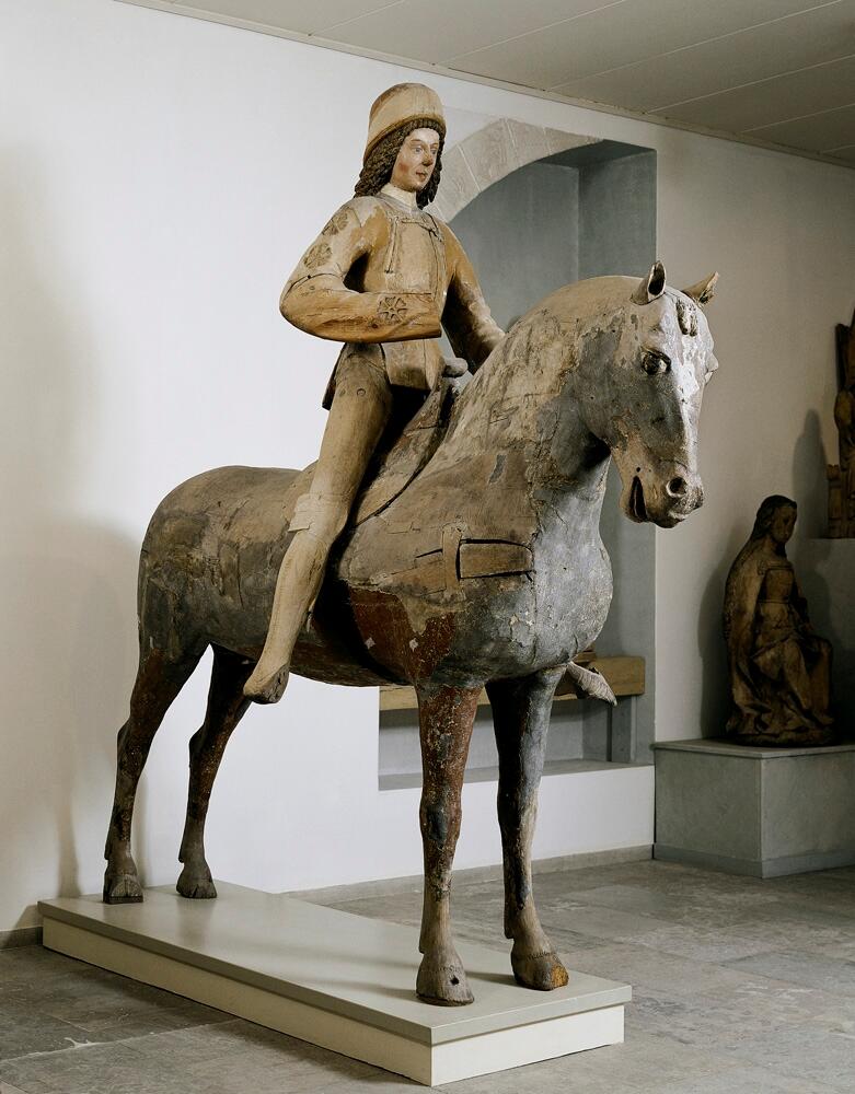 Skulptur av trä föreställande ryttare (Sankt Göran) till häst.

Ryttaren är klädd i delvis försilvrad rustning med guldapplikationer och en guldfärgad vapenrock. Jackan har blomformade urtagningar på armarna. Håret är långt, lockigt och brunt och han bär en nästan cylindrisk huvudbonad. Skulpturen är hel runt om och hästen är ihålig inuti.

Ett rött Göranskors och hästens ursprungliga färg (apelkastad gråskimmel) talar för att det rör sig om en Sankt Görans-gestaltning. Johnny Roosval skriver i "Medeltida konst i Gotlands Fornsal" att skulpturen dateras till tiden 1460-1500. Roosval skriver vidare att skulpturen hört till en enhet med bland annat en drak- och prinsessframställning efter S:t Görans-myten.

Skulpturen har flera tydliga färgrester av bland annat rött och blått på hästen, rött på ryttarens jacka och mössa samt ringbrynjemålning på benen. På hästen finns flera ristade märken: bomärken och initialer, som Roosval daterar till 1500-talet.

Ryttaren restaurerades troligen vid mitten av 1600-talet och omarbetades då till en ryttare från 30-åriga kriget, varvid den lansbärande högerarmen togs bort och troligen ersattes med en arm som förde ett svärd eller en värja i paradställning. Att döma av ett övermålat årtal gjordes detta efter 1647.

Skulpturen är med all säkerhet ett arbete från en verkstad i Lübeck.